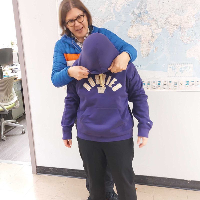 Karen Li being hooded with a purple Huskies hoodie at the Pozzo-group hoodie ceremony